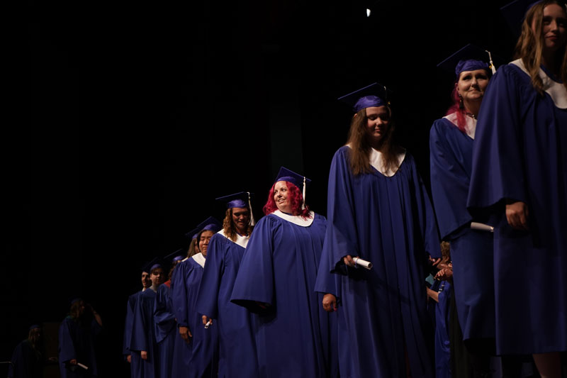 graduates crossing the stage