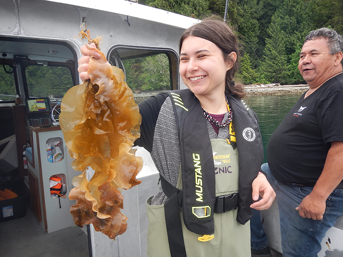 Student holding up a piece of kelp