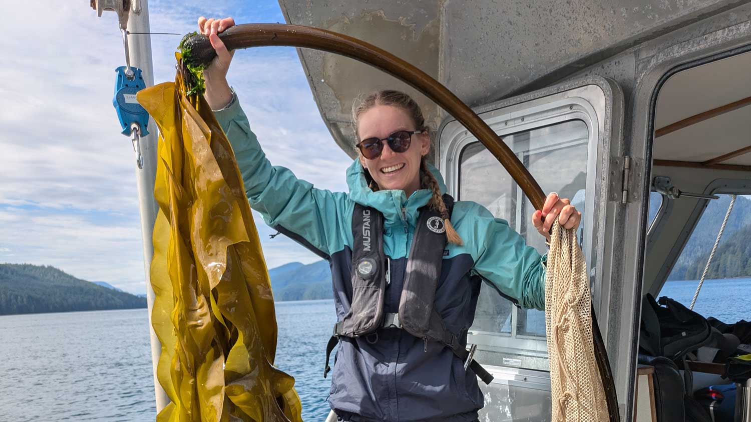 Student research assistant holding up bull kelp