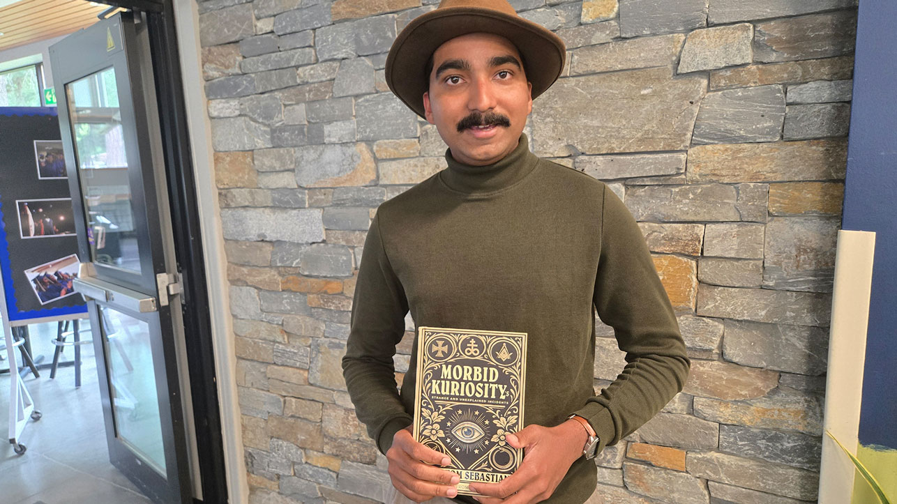 An author holds he wrote and for which he also designed the cover
