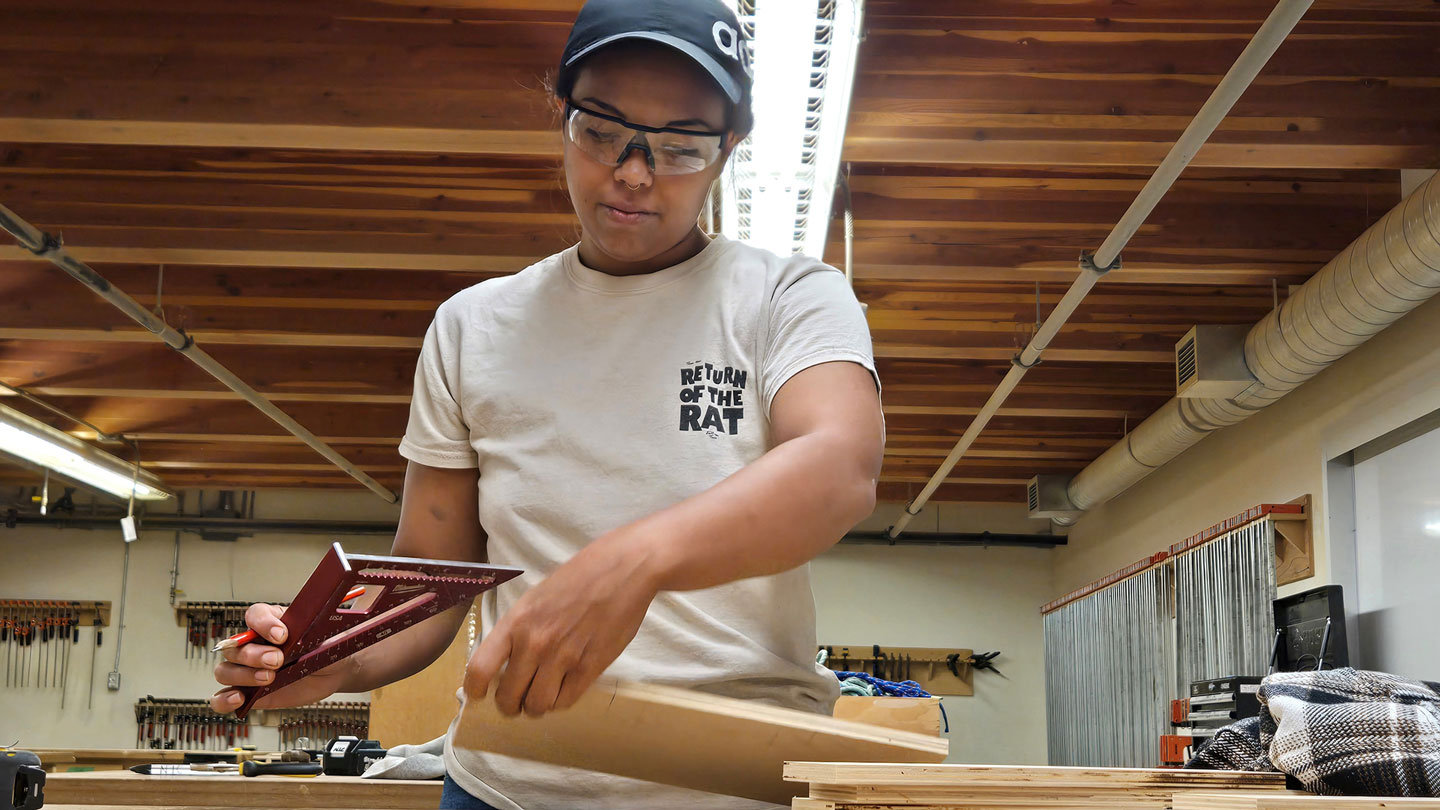 A trade student works on her project in a construction class