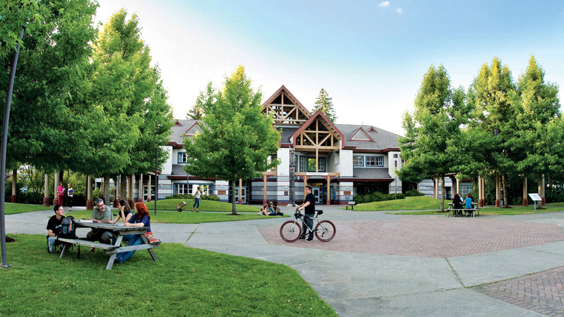 Students sitting or biking outside a college campus