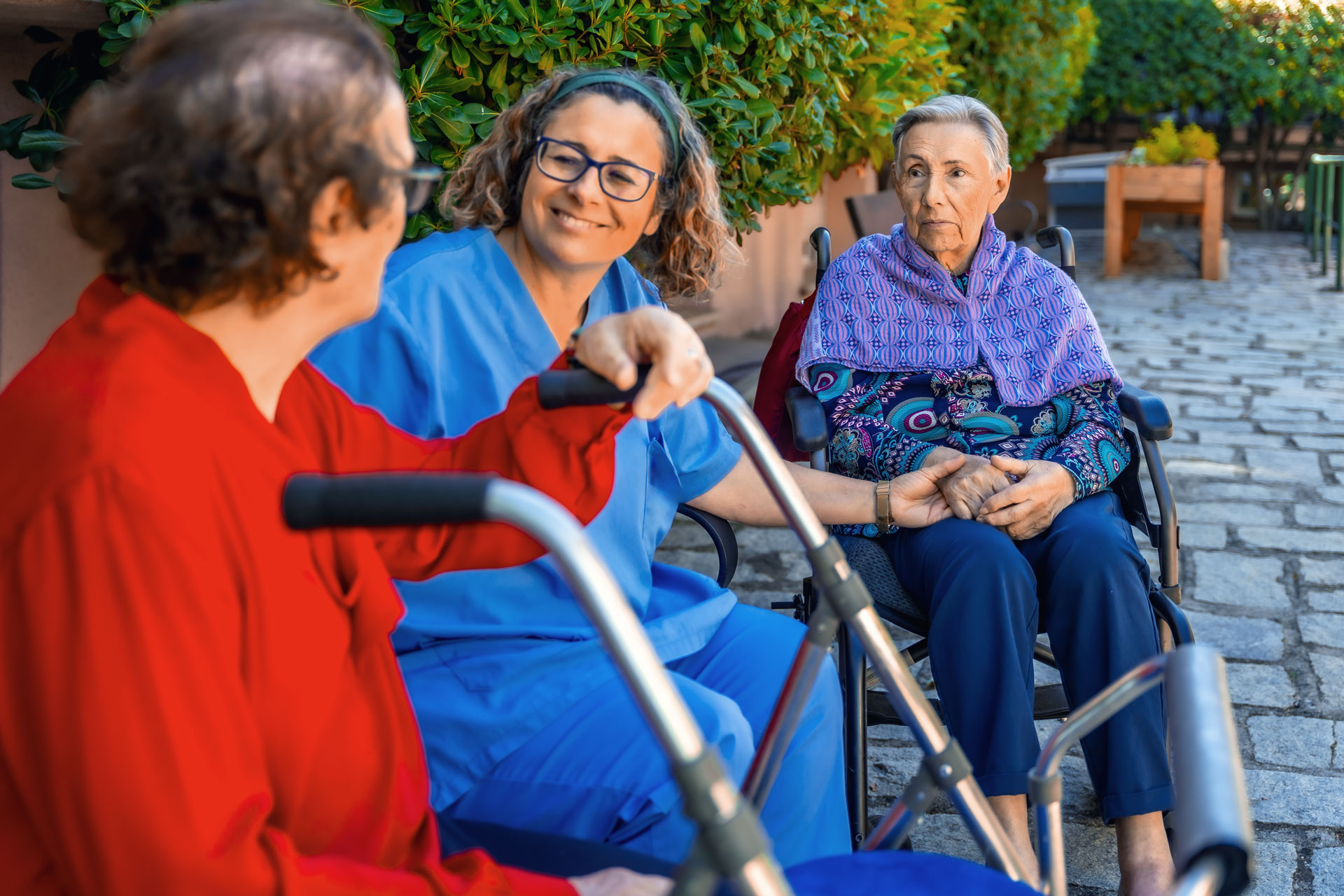 Long term care worker smiling with two residents