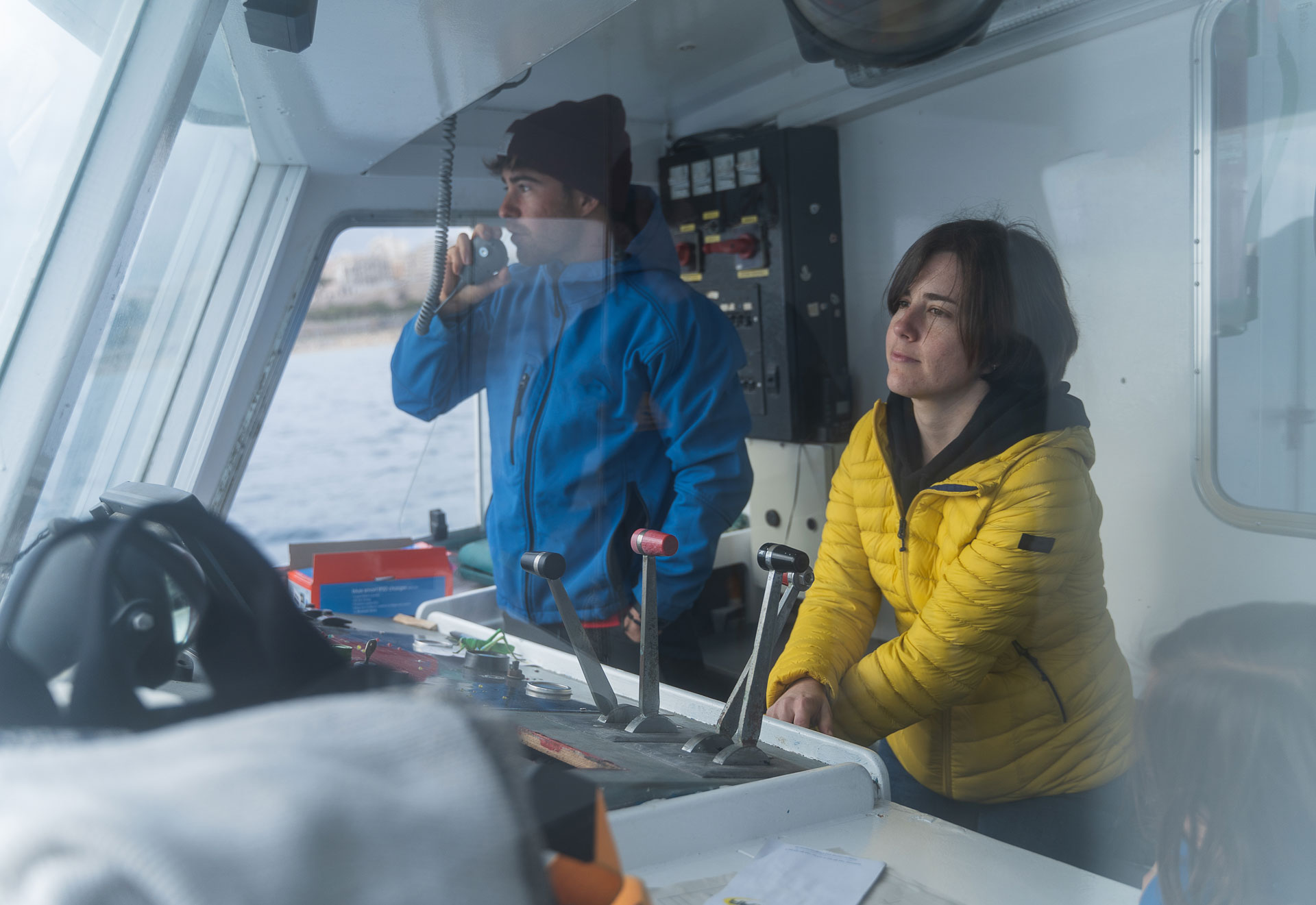 Two people at the helm of a marine vessel